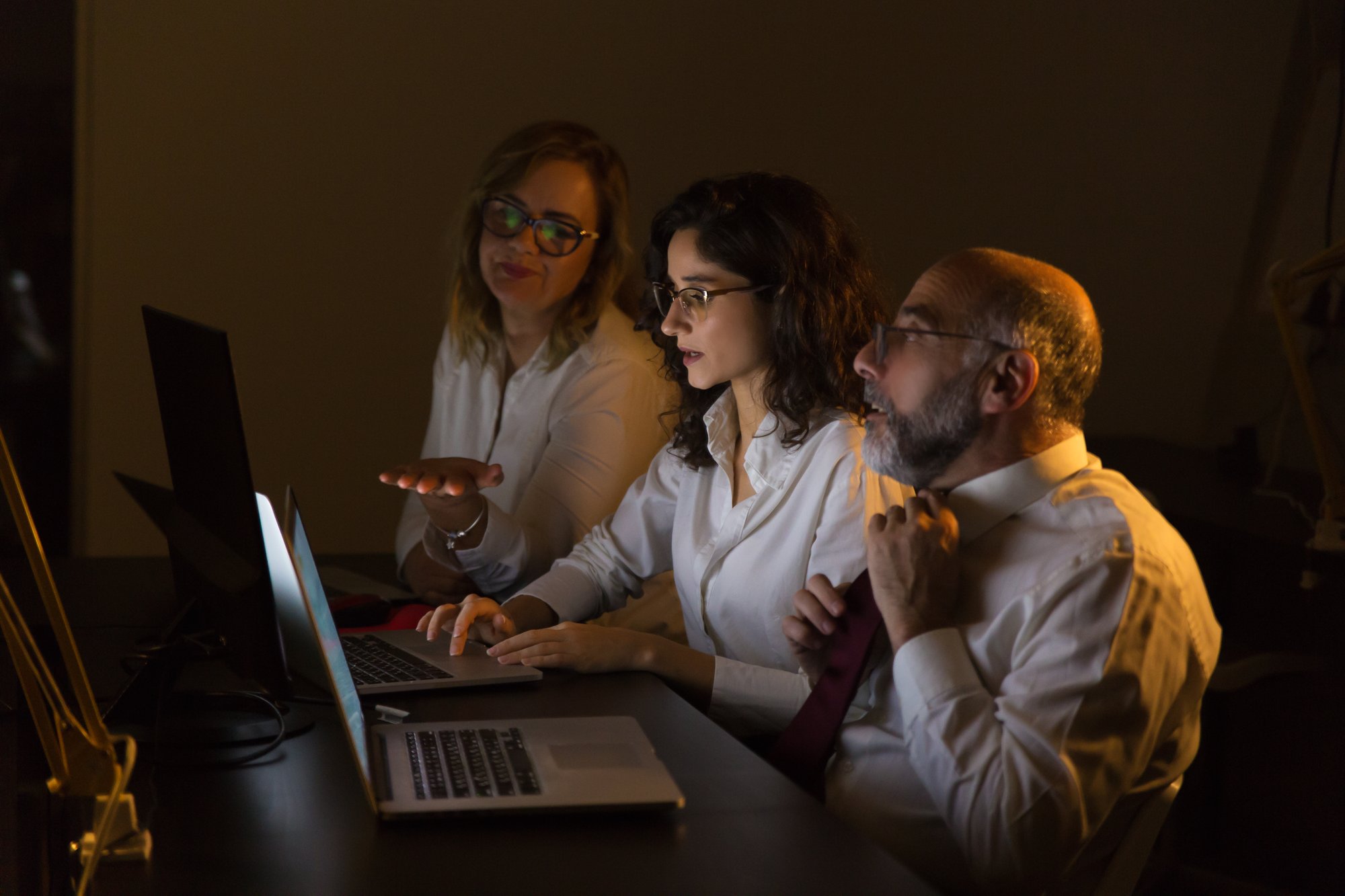 colleagues-discussing-work-dark-office